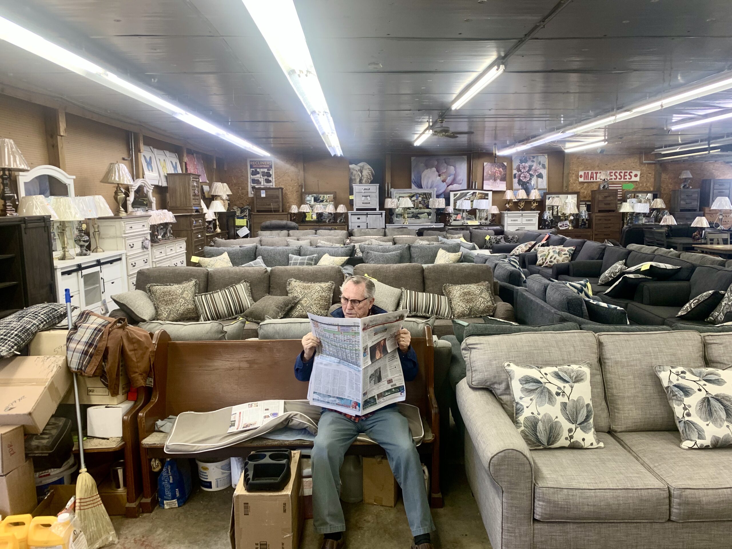 Jim Beacom Sr. sits among 380 Auction Discount Warehouse’s sprawling furniture section, one of many diverse offerings of the low-price inventory. (Shannon M. Venditti).jpeg